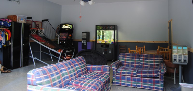 Game room with arcade games, couch and sofa.