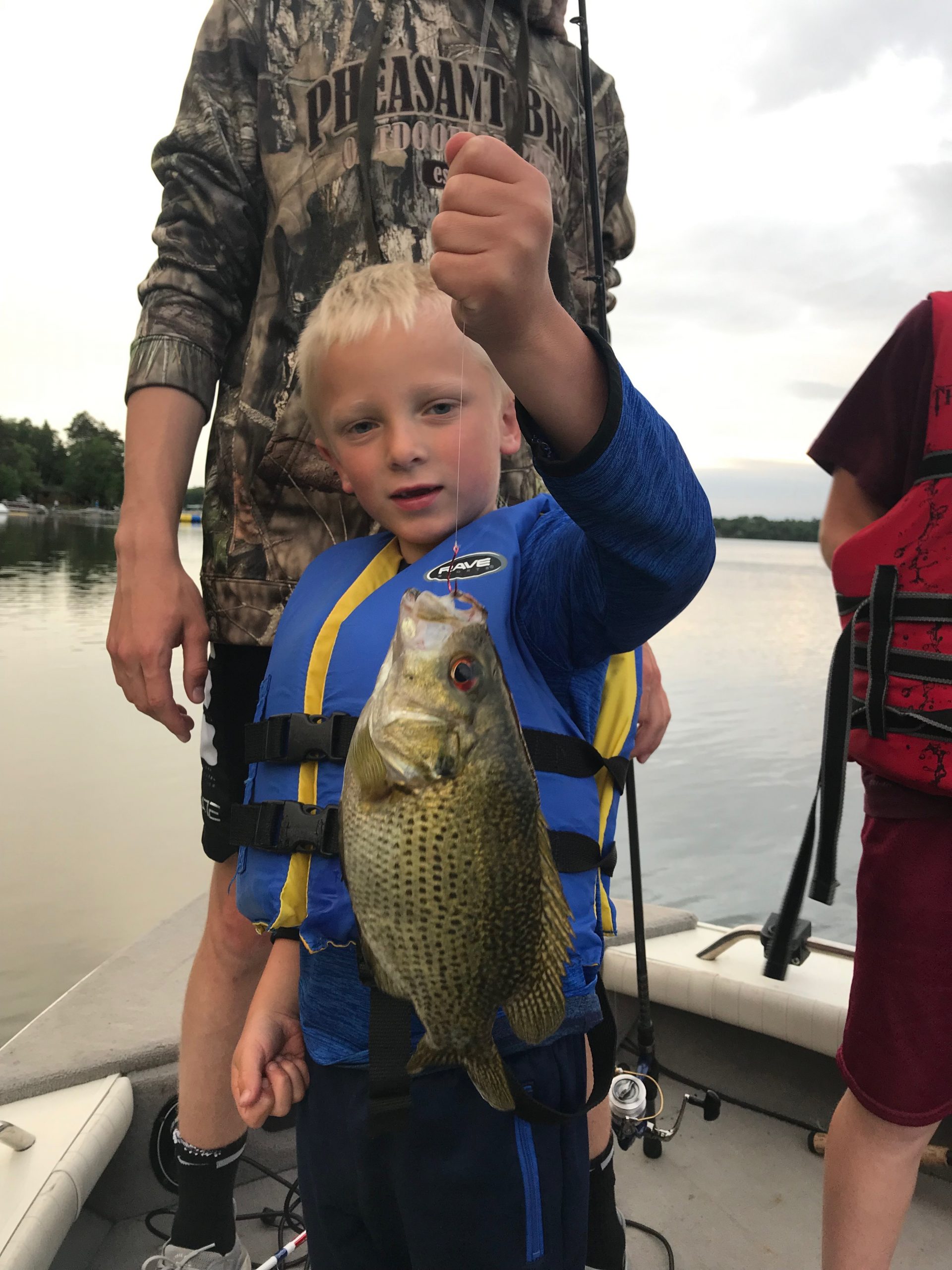 young boy holding fish.